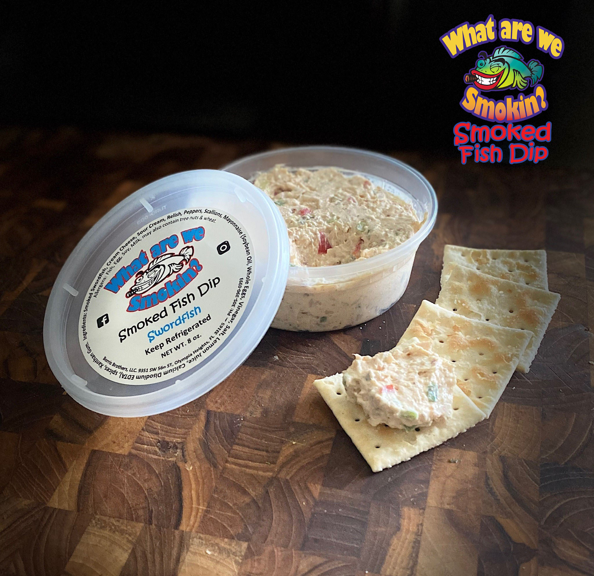 Open tub of What are we smoking smoked fish dips with crackers and logo