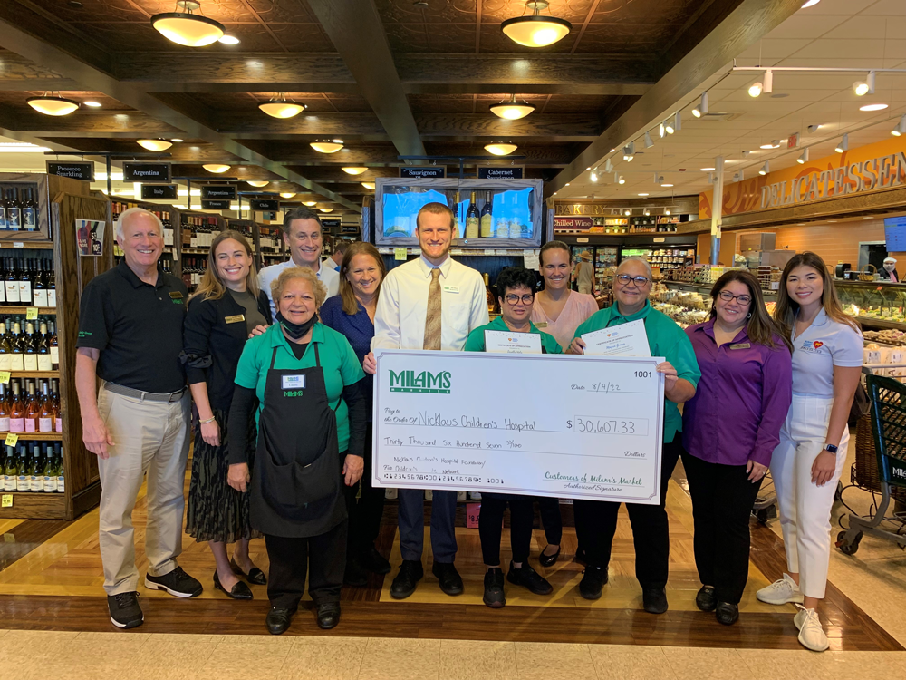 Milam's Market employees holding Nicklaus Children's Hospital donation check