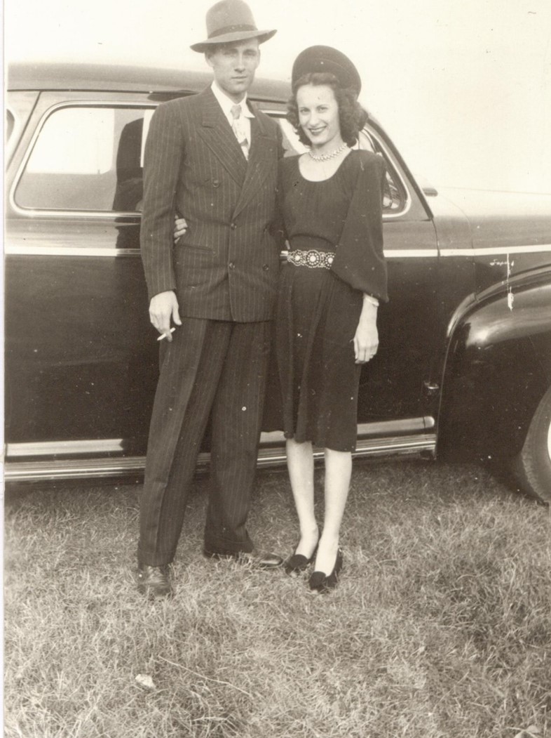 Joan and Thomas Milam standing in front of a car