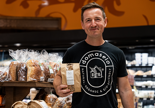 owner of domaselo holding domaselo bread in store